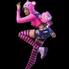 a woman in pink and black striped tights carrying a teddy bear on her back