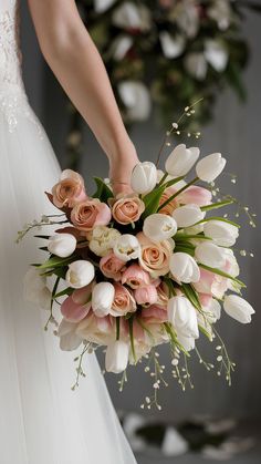 a bride holding a bouquet of white and pink flowers