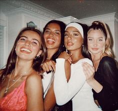 four young women posing for the camera with one holding her arm around another woman's neck