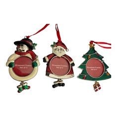 three christmas ornaments are hanging on a white background and one is wearing a santa clause suit