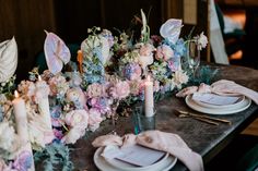 the table is set with flowers and candles