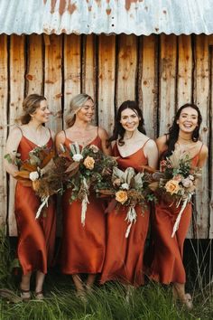 the bridesmaids are all wearing red dresses and holding bouquets in their hands