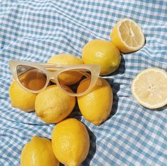 some lemons and sunglasses on a blue checkered cloth