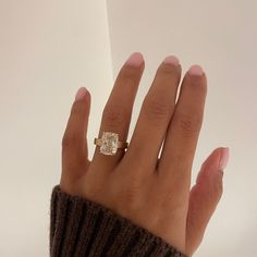 a woman's hand with a diamond ring on it