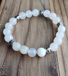 If you're anything like me and take a holistic approach to life, then this is the bracelet for you! Clear quartz is the most useful and versatile of gemstones for metaphysical work. It has the unique property of being "programmable", meaning you can infuse it with your intention and then it will amplify it, working on your behalf to manifest it in the world. It also acts to amplify the energies of any other stone you are working with. DETAILS: * Beautiful White Quartz beads with silver pendants.   MATERIALS: * 8mm (grade AA) white quartz beads  * beautiful silver pendants * strong elastic cord    CRAFTSMANSHIP * every bracelet is handmade by me: Crystal, here at my home studio in Chicago * every bead is handpicked and strung on strong elastic cord to ensure beautiful, lasting quality!    G Cheap White Bohemian Beaded Bracelets, Cheap White Adjustable Beaded Bracelets, Cheap White Hand Wrapped Beaded Bracelets, Cheap White Stretch Bracelet For Meditation, Cheap White Hand-wrapped Beaded Bracelets, Yoga Bracelet Beads, Diy Bracelets With String, Yoga Beads, Meditation Beads