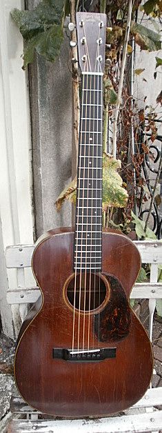 an acoustic guitar sitting on top of a white bench