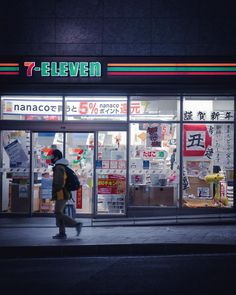 a man walking past a store front at night