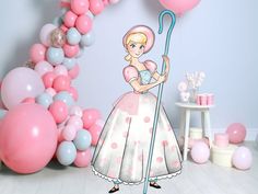 there is a pink and white balloon arch with a princess holding a blue broom in front of it