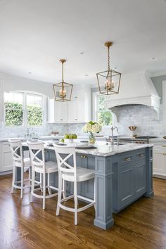 a kitchen with white cabinets and blue island