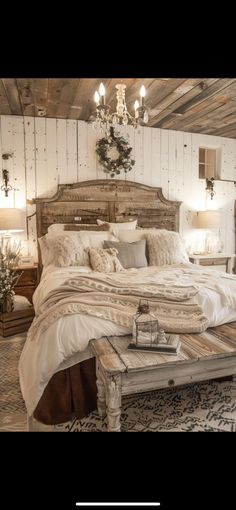 a large bed sitting inside of a bedroom under a chandelier