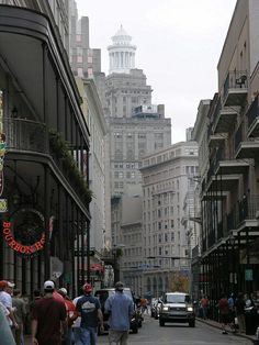 people walking down the street in front of tall buildings