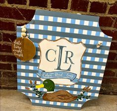 a blue and white sign with a duck on it's side next to a brick wall