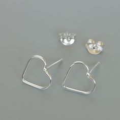 ONE PAIR of sterling silver heart ear studs. Dimensions: 10 x 9 Weight: 0.52 gm These earrings are made of 925 hypoallergenic sterling silver. Please note this price is for ONE PAIR only. All my pieces are sent in a gift box. I can include a personal message from you if needed You are welcome to contact me at... bhavnakwintra1956@gmail.com For more beautiful pieces from my shop, please browse 👇 TOE RINGS: https://www.etsy.com/your/shops/TheSilverGame/tools/listings/section:27020628,view:table E Modern Sterling Silver Heart Earrings For Gift, Minimalist Sterling Silver Heart Earrings With Ear Wire, Modern Silver Heart Earrings For Gifts, Silver Open Heart Minimalist Earrings, Silver Minimalist Open Heart Earrings, Sterling Silver Minimalist Heart Earrings For Pierced Ears, Sterling Silver Minimalist Heart Earrings, Minimalist Sterling Silver Heart Earrings, Earrings Minimalist