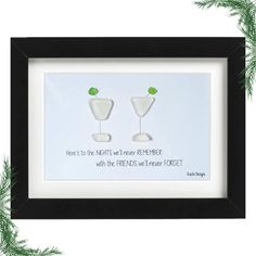 two martinis with green garnish on them are framed in a black frame