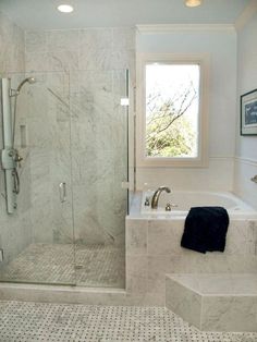 a bathroom with a walk in shower next to a bath tub