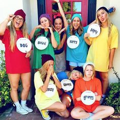 a group of women standing next to each other in front of a door holding up signs