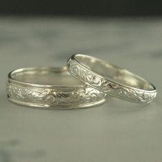 two wedding rings sitting on top of a table