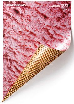 an ice cream cone with pink icing on it's side, next to a white background