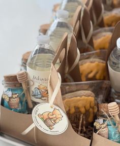 bottles of water and soaps are sitting in a box with brown paper tags on them