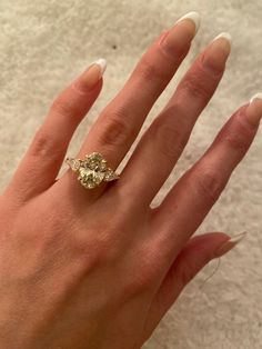 a woman's hand with a three stone ring on top of her left hand