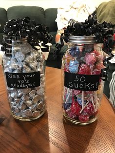 two jars filled with candy sitting on top of a wooden table next to each other