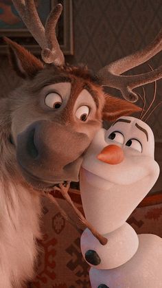 a close up of a cartoon character kissing another character with antlers on their head