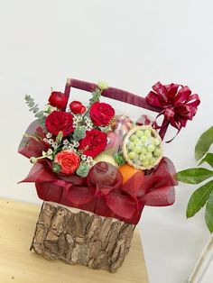 a basket filled with fruit and flowers on top of a wooden table