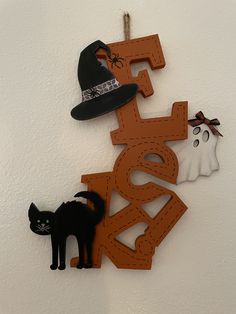 halloween decorations are hanging on the wall next to a black cat and witch's hat