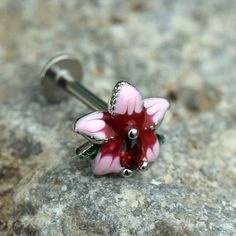 Thank you for choosing our shop for your purchase! * Labret / Monroe with a Flower Design * Detailed hibiscus flower design with petals and leaves * Red color teardrop shaped CZ in the center of the flower * Bar Thickness: 16GA | 1.2mm * Bar Length : 5/16" | 8mm * Flower Design Size : 8.5(L) x 8(W)mm * Thread Type: Externally Threaded * Material: 316L Stainless Steel, Zinc Alloy, Enamel, Cubic Zirconia For more click here:  https://www.etsy.com/shop/TheSaBrieCollective?ref=seller-platform-mcnav  Follow Us on Instagram: @thesabriecollective ALL BODY JEWELRY SALES ARE FINAL. These are items that a going on/in your body and it is not sanitary for a resale. So please, ensure that your gauge and length are what you need and fit your piercing. Nickel-free Red Flower Jewelry, Hibiscus Flower Design, Tragus Ring, Cartilage Ring, Labret Studs, Flower Bar, Flower Ear, Flat Back Earrings, Helix Earrings