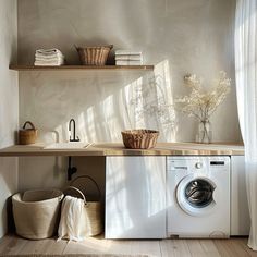 a washer and dryer sitting in a room next to shelves with towels on them