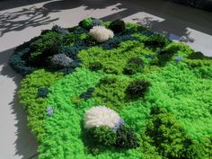 a green and white cake with flowers on it's side, in the shape of a circle