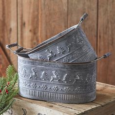 two galvanige buckets sitting on top of a wooden crate next to a christmas tree