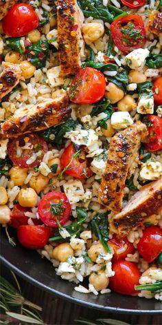 a pan filled with chicken, rice and tomatoes