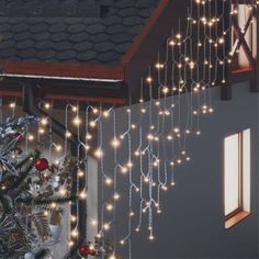 a christmas tree with lights hanging from it's side next to a window in a house