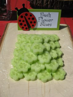 there is a ladybug on top of the green slices that are ready to be cut