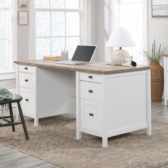 a white desk with a laptop on it in front of a chair and window sill