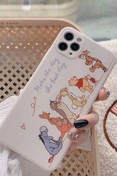 a person holding up a phone case with winnie the pooh characters on it in their hand