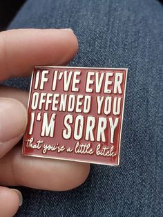 a person holding a red and white pin with the words if i've ever offered you i'm sorry