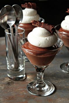 three desserts in small glasses on a table