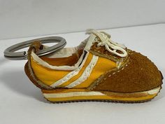 a pair of yellow shoes with white laces on them and a keychain