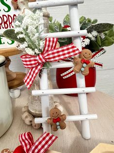 a wooden ladder with teddy bears and flowers in it sitting on a table next to other items