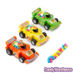 three toy cars with candy in them sitting next to each other on a white background