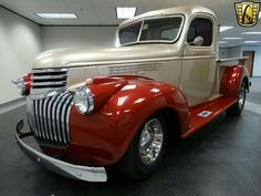 an old red truck is parked in a garage