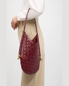 "Find BOTTEGA VENETA Small Solstice Shoulder Bag on Editorialist. The Bottega Veneta \"Solstice\" shoulder bag is crafted from intrecciato lambskin leather. The bag features a rolled shoulder strap with metal knots on the sides. The bag has an open top with a self-tie closure and an interior leashed zip pouch bag. The bag is lined with leather and measures approximately 11.8\"H x 10.2\"W x 0.8\"D. The bag is made in Italy." Luxury Handheld Bucket Bag For Office, Designer Handheld Bucket Bag, Elegant Woven Leather Hobo Bag For Travel, Luxury Bucket Bag With Leather Handles, Elegant Woven Leather Hobo Tote Bag, Designer Bucket Bag With Leather Handles For Office, Luxury Handheld Bucket Bag For Formal Occasions, Luxury Formal Handheld Bucket Bag, Luxury Handheld Hobo Bag