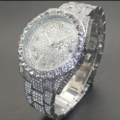 This Watch Is Completely Blinged Out And Heavy. Features: Silverplated Metal Stainless Steel Strap Metal Case Round Dial Shape Is Not Waterproof Quartz Movement Electronic Drive Mode Calendar Simulated Diamonds (Cz) Pointer Display Nice Quality Weight Men Jewelry Silver, Classic Silver Iced Out Diamond Watch, Iced Out White Gold Jewelry For Anniversary, Silver Diamond Watches With Bling, Timeless Silver Iced Out Jewelry, Iced Out White Gold Jewelry And Watches For Anniversary, Timeless Iced Out Silver Jewelry, Formal Diamond White Bling Watch, Formal Iced Out Round Jewelry And Watches