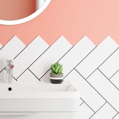 a white sink sitting under a round mirror next to a wall mounted faucet