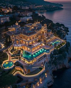 an aerial view of a mansion at night with lights on the roof and pool area