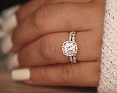 a woman's hand with a diamond ring on it