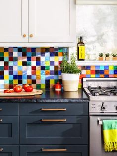 the kitchen counter is covered with colorful tiles and bowls of fruit are on the counter