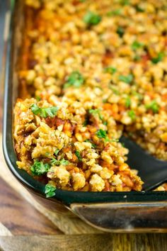 a casserole dish filled with stuffing and garnished with parsley